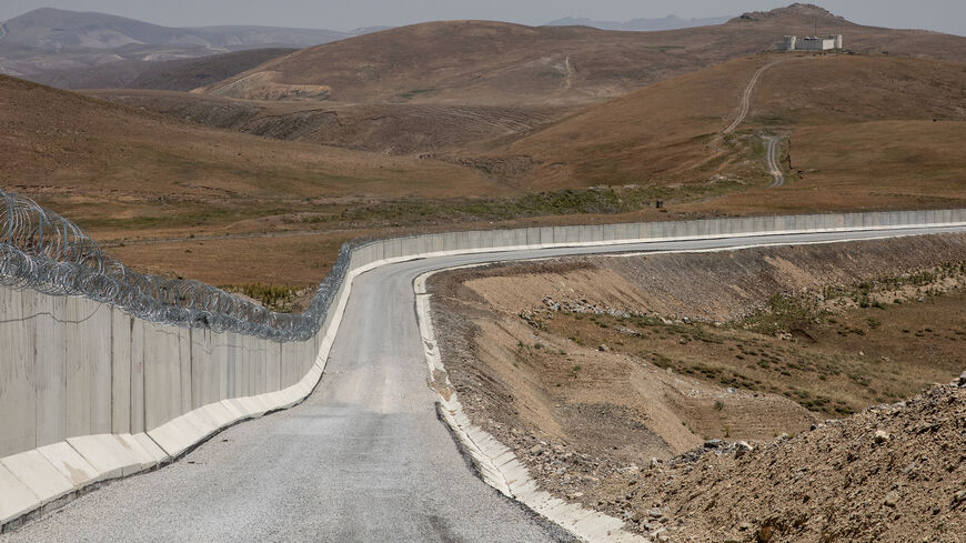 An Iranian border outpost is seen behind a part of Turkey’s newly completed border wall on the Turkey-Iran border, Caldiran, Turkey, July 10, 2021.